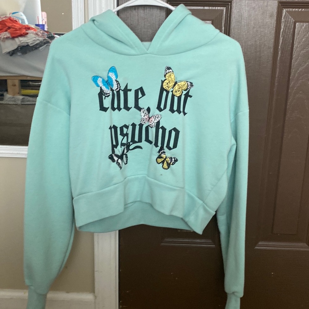 Cropped Adult Medium light blue “Cute but Physco” long sleeved sweater.